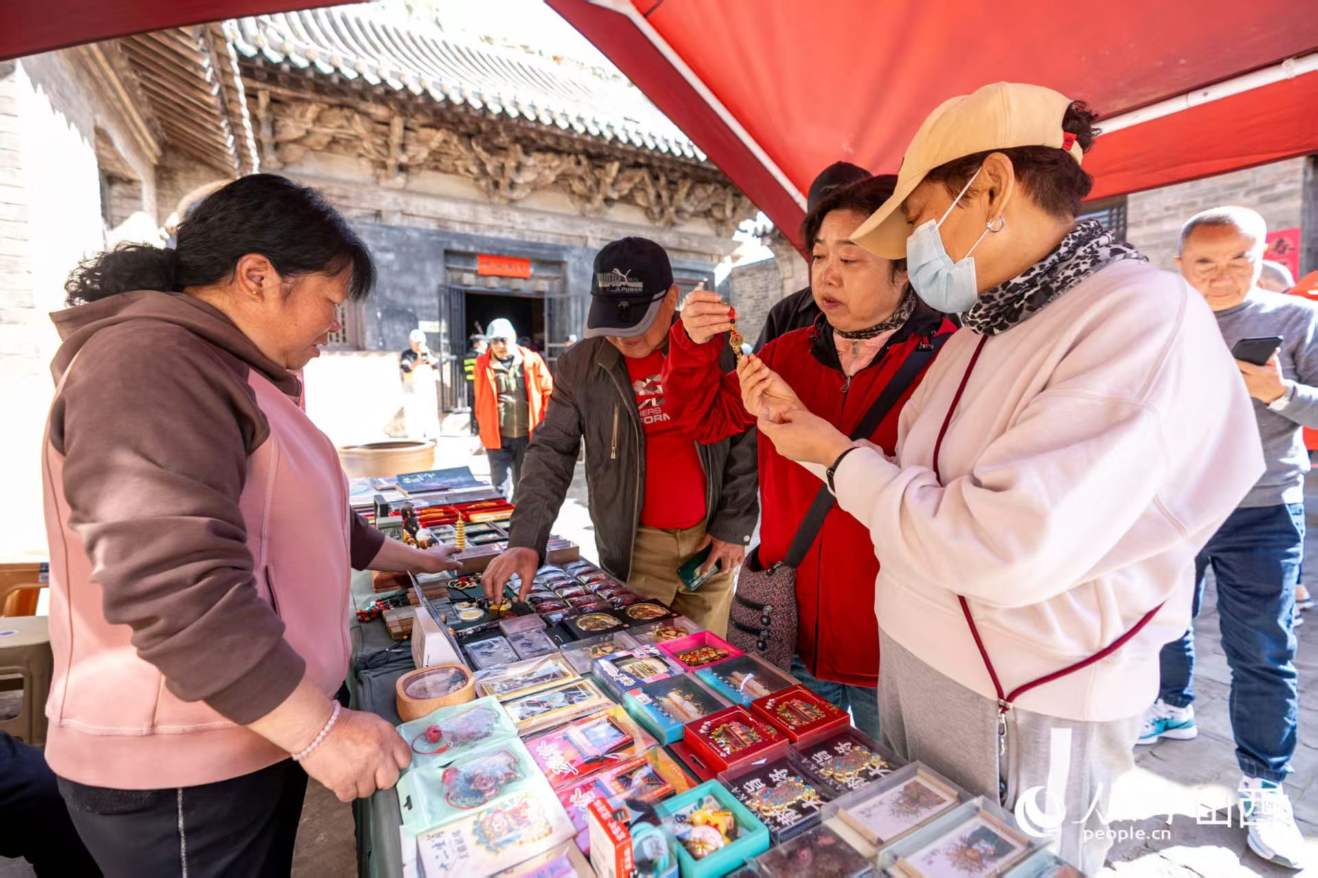 游客在山西省高平市鐵佛寺選購(gòu)文創(chuàng)產(chǎn)品。人民網(wǎng)記者 盧鵬宇攝