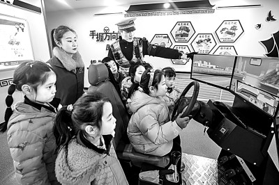 山東省榮成市公安局道路交通安全宣傳教育基地，交警帶領(lǐng)小學(xué)生現(xiàn)場體驗(yàn)?zāi)M駕駛。新華社發(fā)