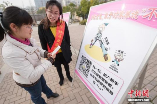 資料圖：今年3月8日，安徽合肥新華社區(qū)志愿者夏一瓊(右)向市民普及反家暴相關(guān)法律知識。鐘欣 攝